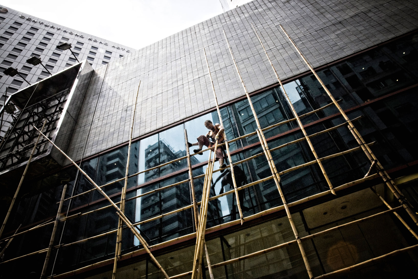 CHINA. Hong Kong, October 2012. A worker prepares a bamboo scaffold.